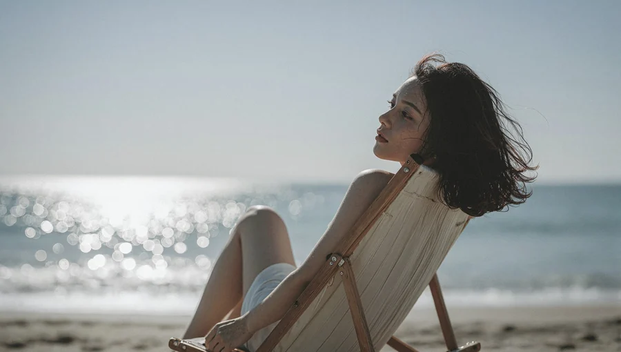 Young Woman In Beach Chair At Sunset